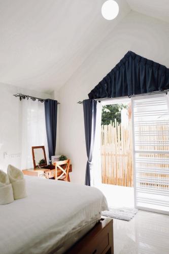 a bedroom with a bed and a large window at TakFha Café & Resort in Ban Tha Ngam (1)