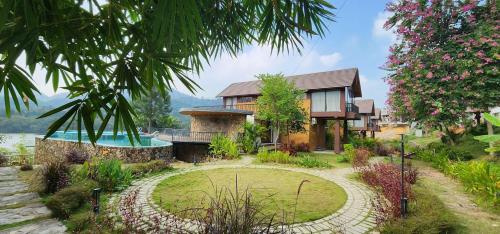 a house with a garden and a swimming pool at Thang Mây Resort - Villa Lake View and Pool View - Hướng hồ và hướng bể bơi in Ba Vì