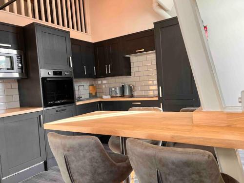 a kitchen with a wooden table and chairs at Potters Loft, Bowness Centre, Parking, Lake Access in Bowness-on-Windermere