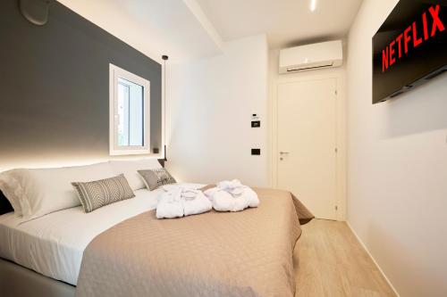 una camera da letto con un letto e due asciugamani di The Twins 2 Luxury Home - Lungomare Viale Milano 20 a Riccione