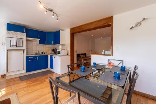 a kitchen and dining room with a table and chairs at Les Sapins in Rochefort-en-Terre