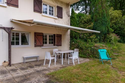 a table and chairs in front of a house at Les Sapins in Rochefort-en-Terre