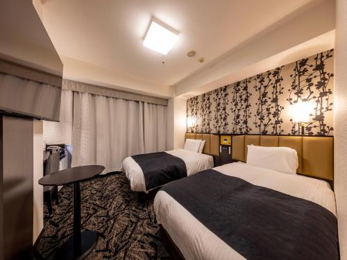 Llit o llits en una habitació de APA Hotel Kanazawa Chuo