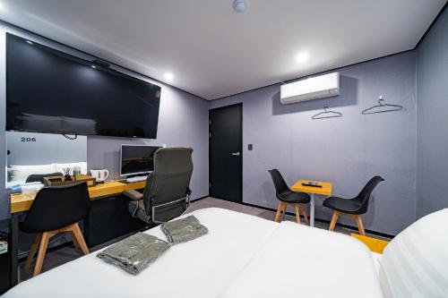 a bedroom with a bed and a desk and chairs at Seven Hotel in Gimje