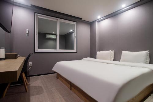 a bedroom with a bed and a window and a desk at Seven Hotel in Gimje
