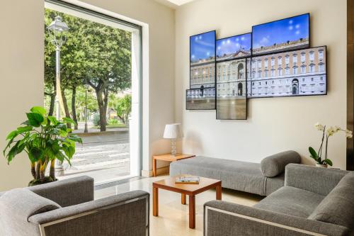 a living room with two couches and a large window at Hotel dei Cavalieri Caserta - La Reggia in Caserta