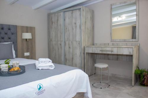 a bedroom with a bed with a vanity and a mirror at Potamos Studios by GERANI in Órmos