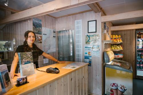 a woman standing at a counter in a store at Vinje Camping in Geiranger