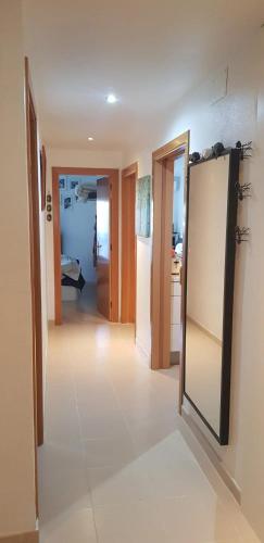 a living room with a mirror and a kitchen at Modern Apartment in Calafell + Terrace in Calafell