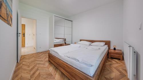 a bedroom with a large bed with white sheets at Belnihel, Sun & Snow in Hel