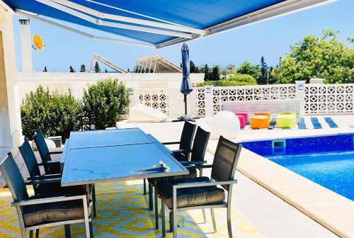a patio with a table and chairs next to a swimming pool at Chambre vue mer dans Villa à la Marina in Alicante
