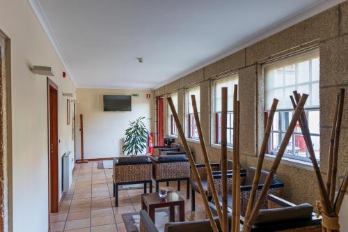a room with chairs and a wall with windows at Hotel Rural Quinta de Sao Sebastiao in Barroselas