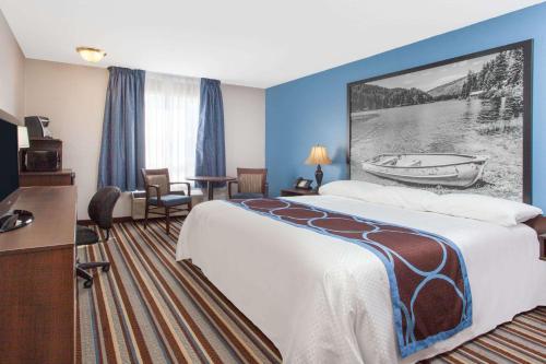 Pokój hotelowy z dużym łóżkiem i biurkiem w obiekcie Super 8 by Wyndham Fort Frances w Fort Frances