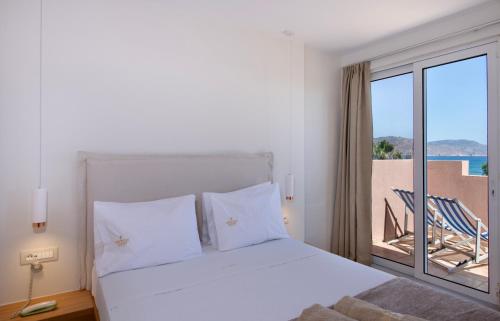 a bedroom with a bed and a balcony with a view at Orpheas Resort Hotel (Adults Only) in Georgioupolis