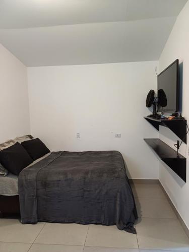 Schlafzimmer mit einem Bett und einem Flachbild-TV in der Unterkunft casa com bela vista em Bragança Paulista in Bragança Paulista