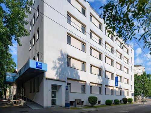 un edificio blanco con una señal azul en ibis budget Hotel Luzern City, en Lucerna