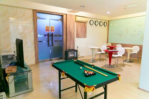 a living room with a pool table and chairs at Travelers A Korea Hostel in Seoul