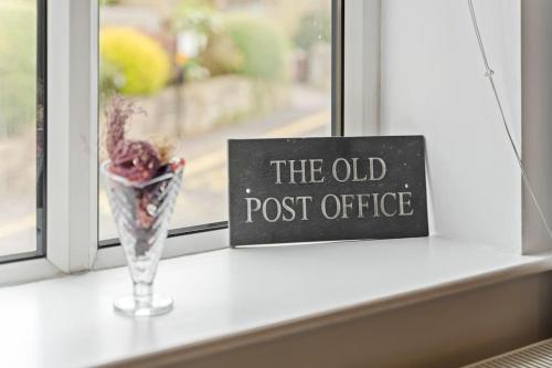 a vase sitting on a window sill next to a post office sign at The Old Post Office 5 mins Drive to Alton Towers in Alton