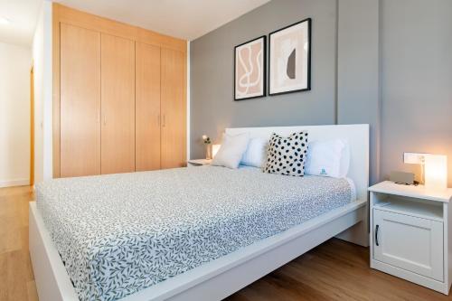 een slaapkamer met een wit bed met blauwe en witte lakens bij Barista Homes in San Miguel de Abona