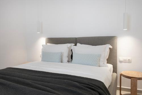 duże łóżko z białą pościelą i niebieskimi poduszkami w obiekcie Ornos Vibes 2 w mieście Ornos