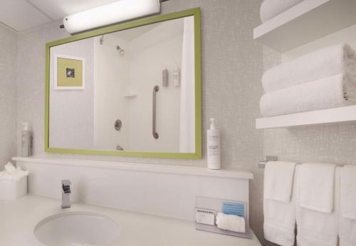 a bathroom with a sink and a mirror and towels at Hampton Inn Hotel Atlanta-Southlake in Morrow