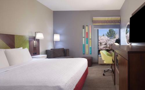 a hotel room with a large bed and a television at Hampton Inn Hotel Atlanta-Southlake in Morrow