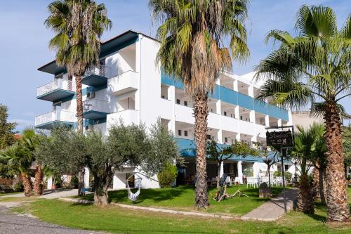 a hotel with palm trees in front of it at Zoe Seaside in Loutra Edipsou