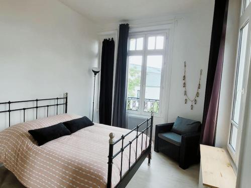 une chambre avec un lit, une chaise et une fenêtre dans l'établissement Appartement lumineux en centre-ville avec parking, à La Rochelle