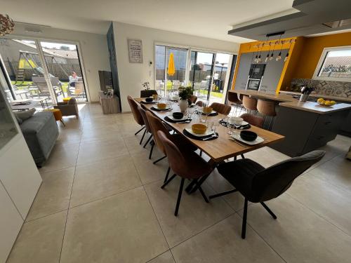 une salle à manger avec une longue table et des chaises dans l'établissement Villa Veillon 10 voyageurs, à Talmont-Saint-Hilaire