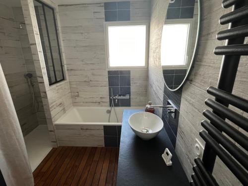 une salle de bain avec une baignoire et un lavabo et une baignoire dans l'établissement Villa Veillon 10 voyageurs, à Talmont-Saint-Hilaire