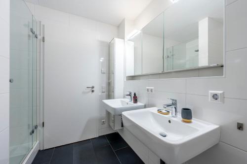 a white bathroom with a sink and a mirror at EXQUIS 2BR Design Apartment LOUIS I Parking I Balcony I Mercedes-Benz I Family-friendly in Böblingen