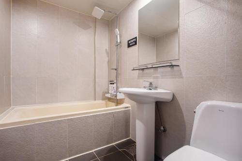 a bathroom with a sink and a toilet and a tub at Seven Hotel in Gimje
