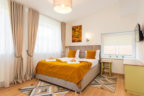 a bedroom with a bed with orange sheets and a window at 1912 Bed & Breakfast in Klaipėda