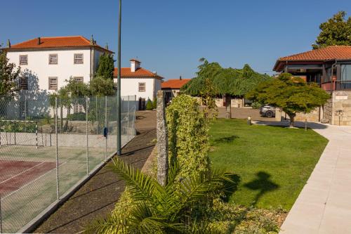 a fence in front of a yard with a house at Hotel Rural Quinta de Sao Sebastiao in Barroselas