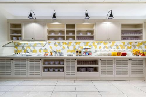 a kitchen with white cabinets and yellow tiles at Hyatt Place Blacksburg/University in Blacksburg