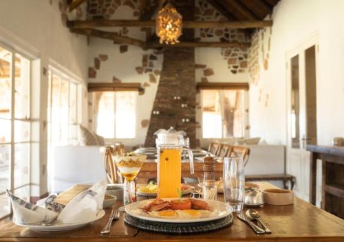 HwangeHideaways Nantwich Lodge, Hwange的一张木桌,上面有盘子的食物