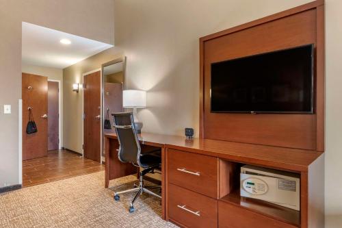 a room with a desk with a tv and a chair at Comfort Suites Manheim - Lancaster in Manheim