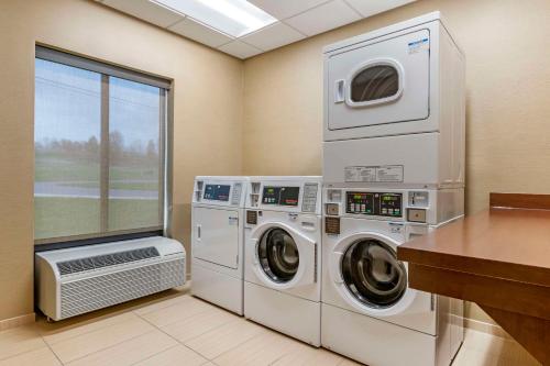 a laundry room with two washing machines and a window at Comfort Suites Manheim - Lancaster in Manheim