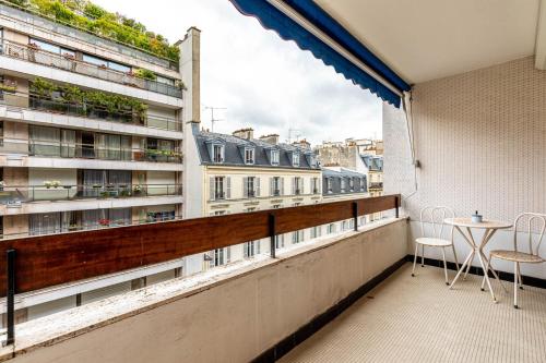 - un balcon avec une table et des chaises dans l'établissement GuestReady - One perfect studio in Auteuil, à Paris