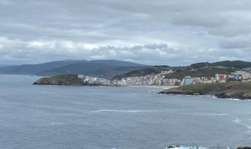 a large body of water with a city in the background at Brisas marinas in Malpica