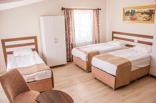 a bedroom with two beds and a table and chairs at Ürgüp Elit Otel in Ürgüp