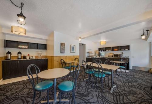 a room with tables and chairs and a kitchen at SureStay Hotel by Best Western Rossland Red Mountain in Rossland