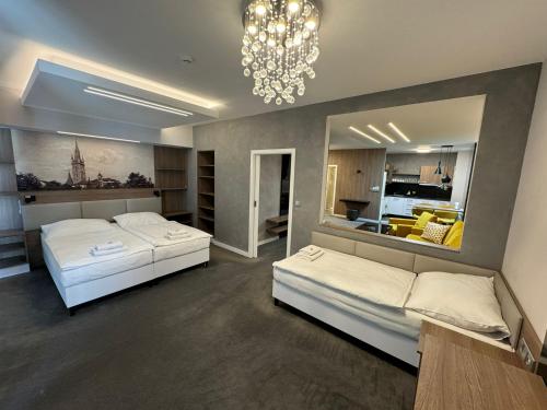 a bedroom with two beds and a chandelier at Hotel Grand in Čáslav