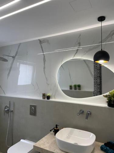 a white bathroom with a sink and a mirror at BeeHouse in Kalithies