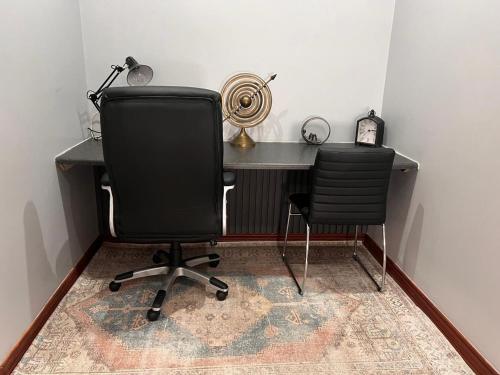 an office with a desk and a chair and a clock at Bluestream Villas in Pretoria
