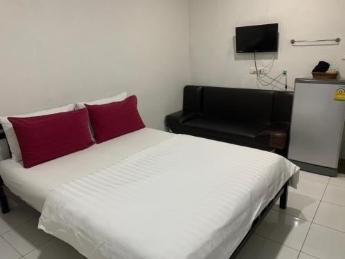 a bedroom with a bed with red pillows and a chair at D Heart Homestay in Bangkok