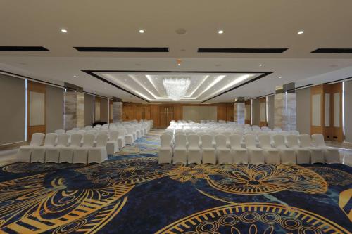 a conference room with white chairs and a carpet at Hilton Garden Inn Pune Hinjawadi in Pune