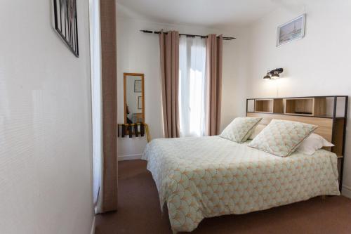 1 dormitorio con cama y ventana en Ideal Hotel en París