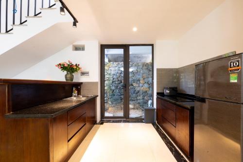 a kitchen with a staircase and a refrigerator at Ivory Villas & Resort - Villa view hồ Lake View in Rống Vong