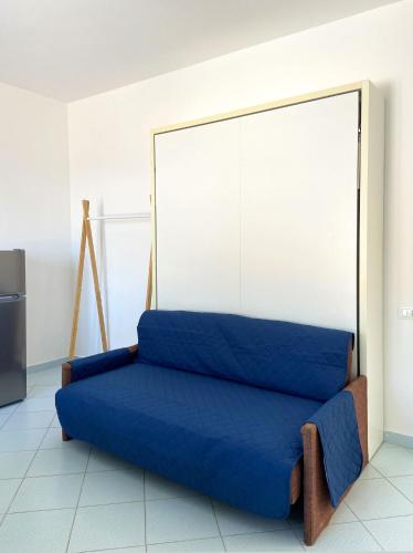 a blue couch sitting in front of a wall at Residence Intur in Marciana Marina